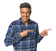 Middle-aged Latino man excited pointing with forefingers away.
