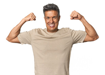 Middle-aged Latino man showing strength gesture with arms, symbol of feminine power