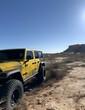 AI generated illustration of A yellow car driving off-road in mountain terrain