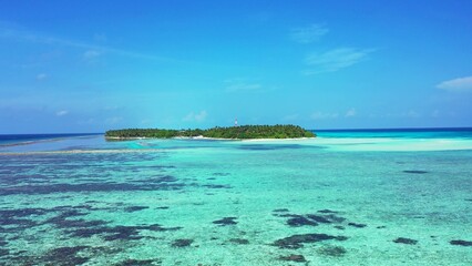 Island with trees surrounded by ocean on a sunny day