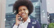 Image of ecology icons over african american businesswoman talking on smartphone