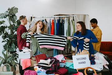 Wall Mural - young people in second hand shops, choice of clothes, the possibility of a second life for clothes, woman take away each other's clothes, having fun