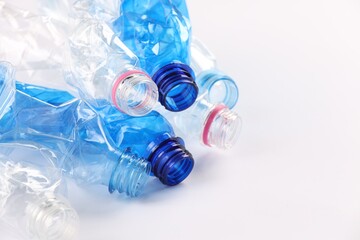 Poster - Crumpled disposable plastic bottles on white background, space for text