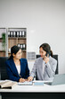 © Nuttapong punna - Businesswomen work and discuss their business plans. A women employee explains and shows her colleague in office.