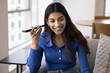 © fizkes - Cheerful young Indian woman holding smartphone at ear, listening to voice message on telephone, smiling, laughing, using media service, internet technology for communication
