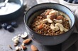 Tasty granola with nuts in bowl on gray table, closeup