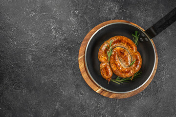 Wall Mural - Snail sausage, Roasted sausage in pan on a dark background. top view. copy space for text