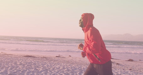 Wall Mural - Image of african american man running at beach