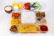 Indian Bengali mixed thali with veggie and non-vegetarian dishes, comprising plain rice, vegetable dishes, spicy fish curry, salad, and dessert.