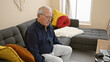 © Krakenimages.com - Serious faced senior man with white hair, comfortably sitting on a cozy sofa, relaxing at home with his eyes closed, a portrayal of mature relaxation in the comfort of indoor living room.