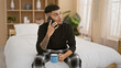 © Krakenimages.com - Handsome, tattooed young adult latin man comfortably relaxing on bed, sipping java, seriously concentrating on phone talk happening on his smartphone amidst cozy room interior