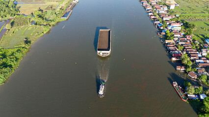 Wall Mural - aerial view of a coal barge passing through a South Kalimantan river