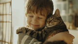 Fototapeta  - Little happy boy tenderly hugs her cat tightly in a bright spacious living room. Friendship concept between humans and animals