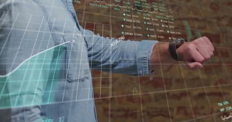 Canvas Print - A businessman is using a smartwatch and a digital tablet with a stock market display