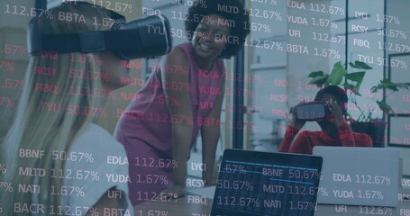 Poster - Image of stock market data processing over two diverse women wearing vr headset at office