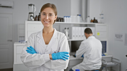 Poster - At the heart of science, two relaxed scientists, a man and woman, standing with arms crossed in the lab - partners in the pursuit of medical research and discovery