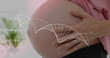 Dna strand over midsection of pregnant caucasian woman touching belly
