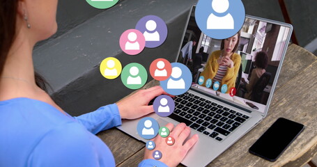 Poster - Image of profile icons floating over rear view of woman having a image call on laptop at a cafe