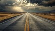 Dramatic clouds over a deserted highway - A scenic view of an empty highway stretching into the distance under a dramatic sky with threatening clouds and streaks of sunlight