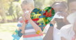 Image of colourful puzzle pieces heart over children blowing their noses