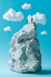 business success concept, mountain rock climbers on plain blue sky studio background with fluffy clouds miniature