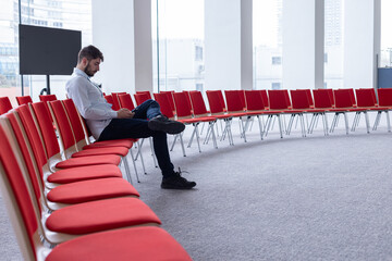 Wall Mural - Portrait d'un homme qui travaille seul, assis dans une salle de réunion ou une salle de conférence avec un ordinateur portable. C'est un homme d'affaires ou un salarié d'une entreprise