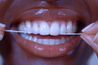 A pair of hands carefully flossing teeth, promoting oral hygiene and dental care
