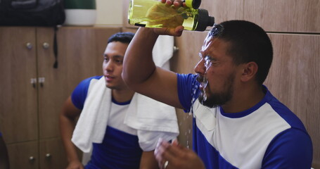Poster - Image of covid-19 cells icons over hispanic male soccer player putting water on his face