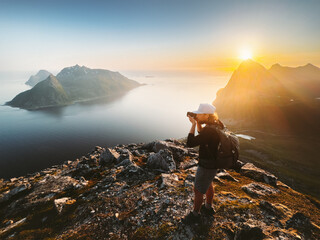 Wall Mural - man photographer travel blogger taking photo by camera of landscape in norway tourist traveling hiki