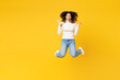 © ViDi Studio - Full body fun little kid teen girl of African American ethnicity wear white casual clothes jump high look camera spread hands isolated on plain yellow background studio. Childhood lifestyle concept.