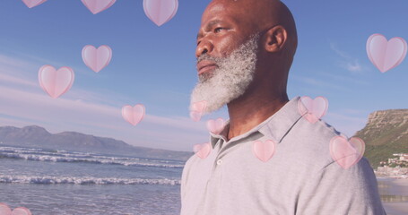 Wall Mural - Image of hearts over senior african american man at beach