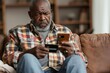 Upset and sad man sitting at home on couch in living room, cheated senior mature african american man displeased holding phone and bank credit card, rejected fund transfer error, Generative AI