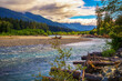 Hoh River flowing through a rocky bed in Olympic National Park surrounded by Hoh Rainforest and Olympic Mountains in Washington State.