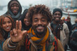 A group of people are smiling and one of them is holding up a peace sign