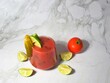 Traditional Bloody Mary cocktail with celery lime and gherkin garnish isolated on marble background