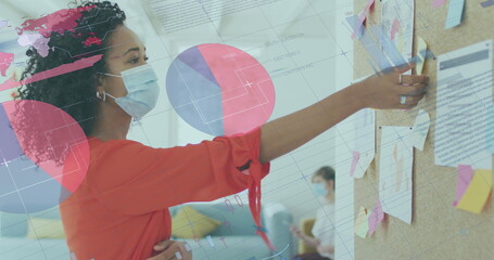 Wall Mural - Image of data processing over biracial businesswoman in face mask in office