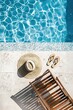 © Larisa - Aerial view of a poolside with hat, sandals, and chair, implying leisure and vacation.
