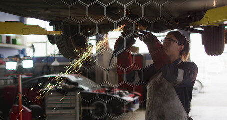 Poster - Image of network of blue hexagons over caucasian woman fixing car
