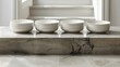   A stack of white plates sits atop a marble counter, near a staircase within a house