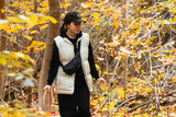 Fototapeta Na drzwi - woman with basket looking for mushrooms in autumn forest