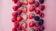   A collection of strawberries and raspberries arranged on a rosy backdrop, with extra strawberries centrally positioned