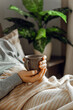 © Olga Miltsova - a caucasian man relaxing at home, drinking coffee in bed under blanket