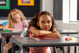 Fototapeta  - In school, young biracial female student sitting at a desk in a classroom, looking thoughtful