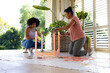 Biracial mother and adult daughter are painting furniture outside at home for an upcycling project