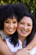 Biracial mother and daughter are hugging, smiling at home in the garden