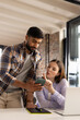 © Wavebreak Media - Asian male and Caucasian female colleagues are examining a smartphone in a modern business office