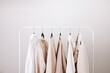 Wardrobe essentials of white and beige colors, stylish woman's closing on the rack