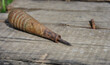 old awl with a wooden handle on an old wooden table. old sewing awl on a wooden background.