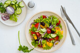 Fototapeta Dinusie - Plate of fresh salad with vegetables on white rustic background