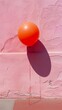 © Ivana - one single orange balloon isolated on pink wall in sunlight